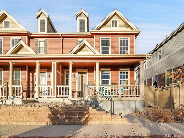 view of front of home featuring a porch and fence