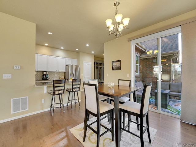 dining room featuring baseboards, visible vents, light wood-style floors, a notable chandelier, and recessed lighting