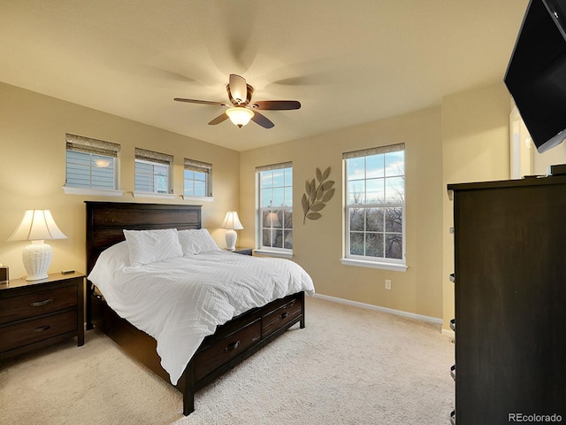 bedroom featuring baseboards, a ceiling fan, and light colored carpet