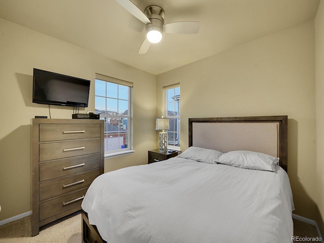 bedroom featuring baseboards, a ceiling fan, and light colored carpet