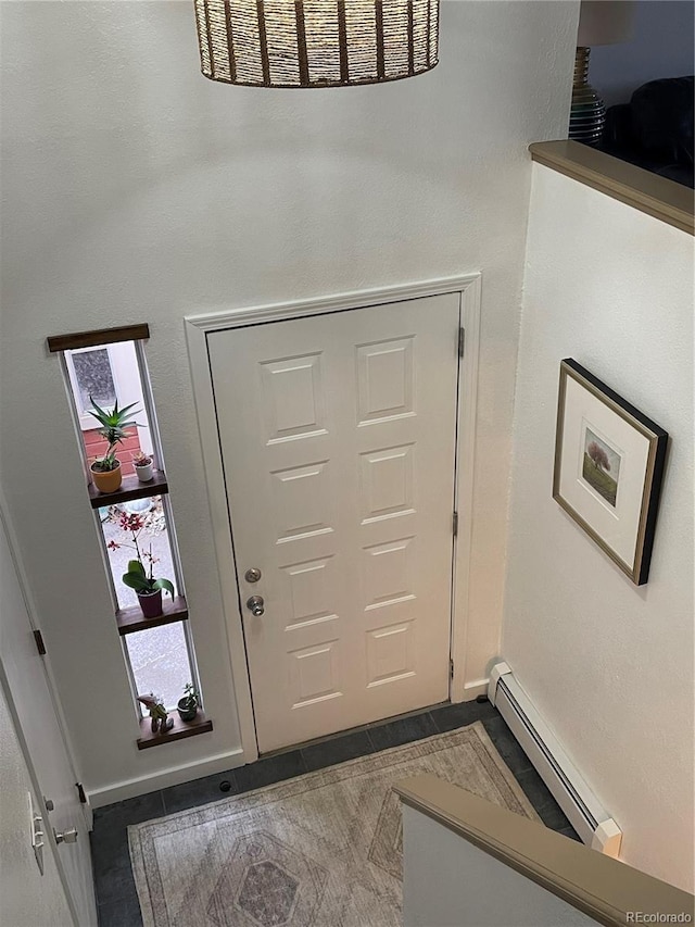 entrance foyer with a baseboard heating unit, tile patterned flooring, and visible vents