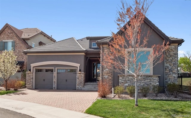 6970 E Lake Dr, Centennial, CO 80111 - view of front of property with an attached garage, decorative driveway, stucco siding, and stone siding