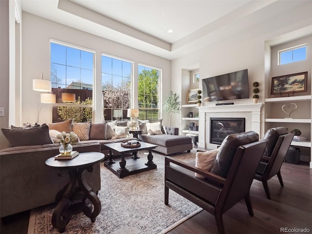 6970 E Lake Dr, Centennial, CO 80111 - living room with built in features, a glass covered fireplace, wood finished floors, and a healthy amount of sunlight