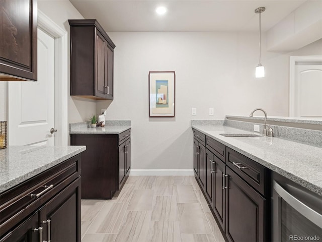 6970 E Lake Dr, Centennial, CO 80111 - kitchen featuring dark brown cabinetry, light stone countertops, a sink, baseboards, and wine cooler