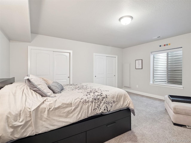 6970 E Lake Dr, Centennial, CO 80111 - bedroom with baseboards, two closets, carpet flooring, and visible vents