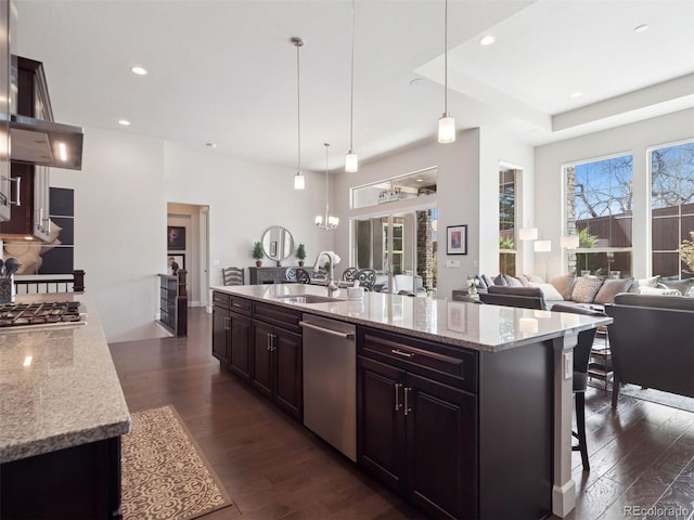 6970 E Lake Dr, Centennial, CO 80111 - kitchen featuring stainless steel appliances, dark wood-style flooring, light stone countertops, a kitchen breakfast bar, and recessed lighting