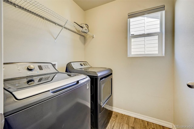 clothes washing area featuring washer and dryer and hardwood / wood-style floors