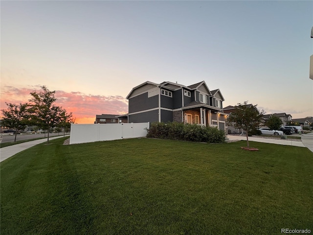 property exterior at dusk with a lawn