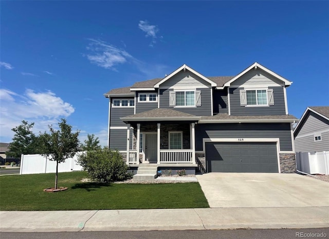 view of front of property with covered porch, a garage, and a front lawn