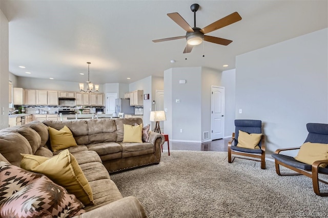 carpeted living room featuring ceiling fan with notable chandelier