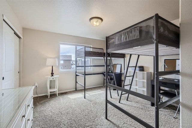 carpeted bedroom featuring a textured ceiling and a closet