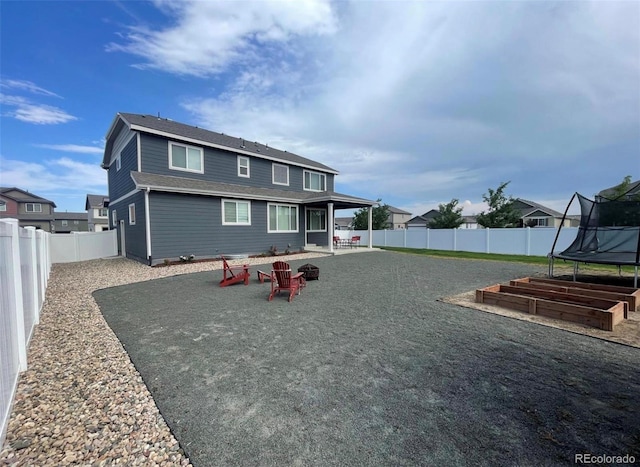 rear view of property with a trampoline