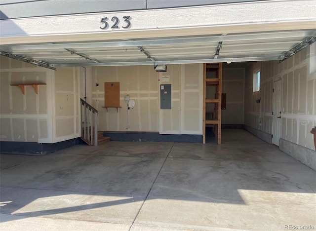 garage with a garage door opener and electric panel