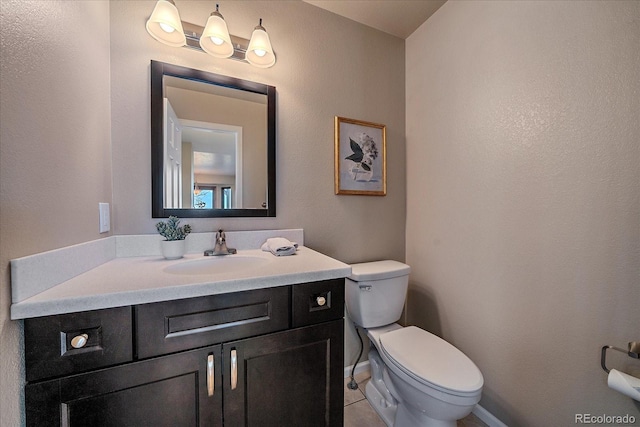 bathroom with toilet, tile patterned floors, and vanity