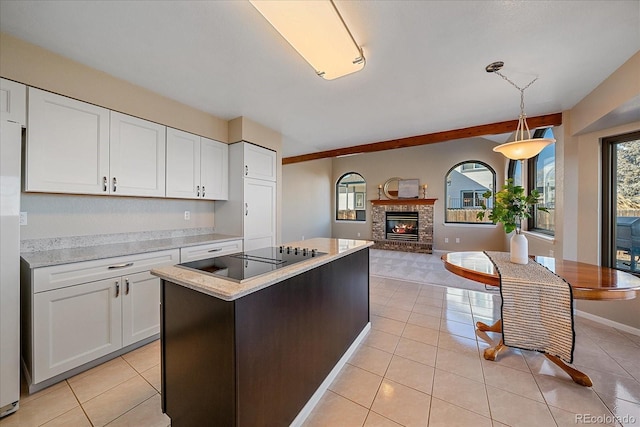 kitchen featuring decorative light fixtures, white cabinetry, light tile patterned floors, and black electric cooktop