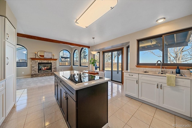 kitchen with white cabinets, light tile patterned flooring, black electric cooktop, and hanging light fixtures