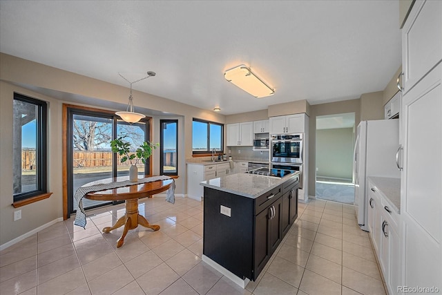 kitchen with white cabinetry, a center island, light tile patterned floors, hanging light fixtures, and appliances with stainless steel finishes