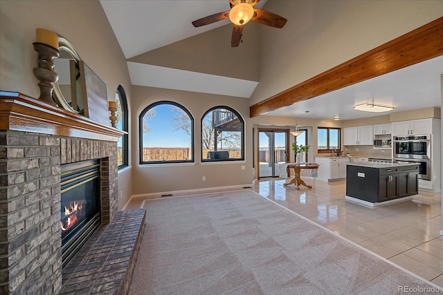 unfurnished living room featuring vaulted ceiling, a brick fireplace, ceiling fan, and light tile patterned floors