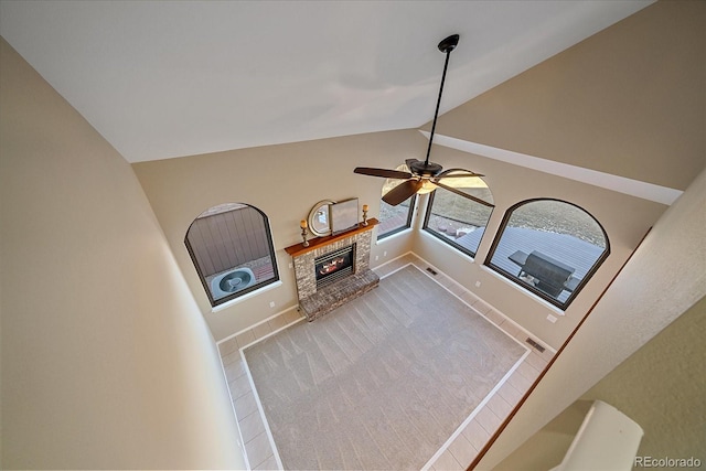 interior space with ceiling fan, a fireplace, and carpet flooring