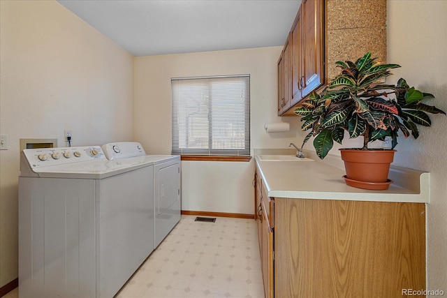 laundry area featuring washer and dryer, cabinets, and sink