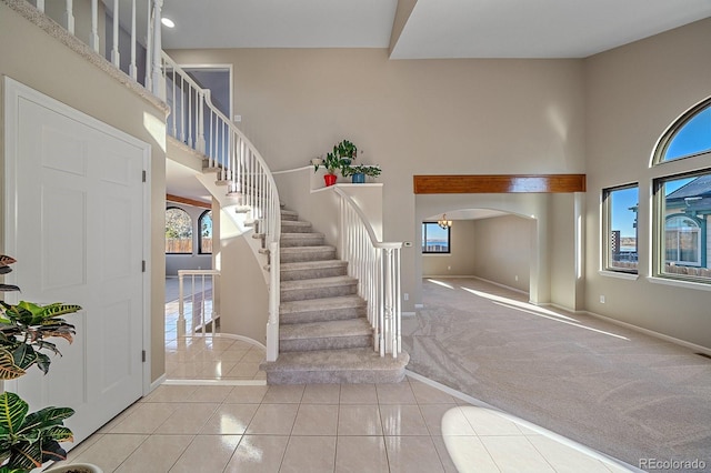 foyer entrance featuring a towering ceiling and light tile patterned floors