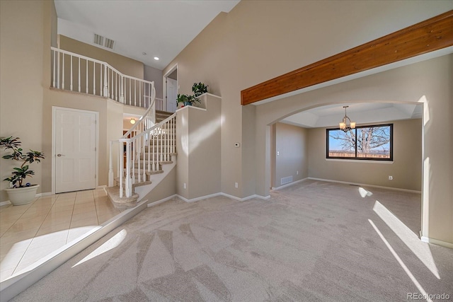 unfurnished living room with a notable chandelier and light carpet