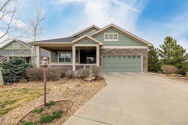 craftsman inspired home with stone siding, a porch, concrete driveway, and an attached garage