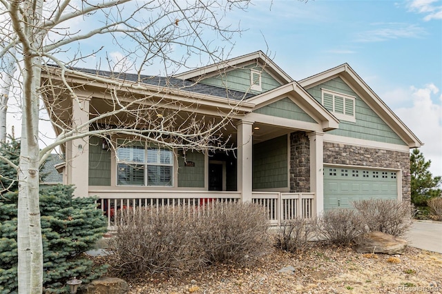 view of front of property with concrete driveway, a garage, covered porch, and stone siding