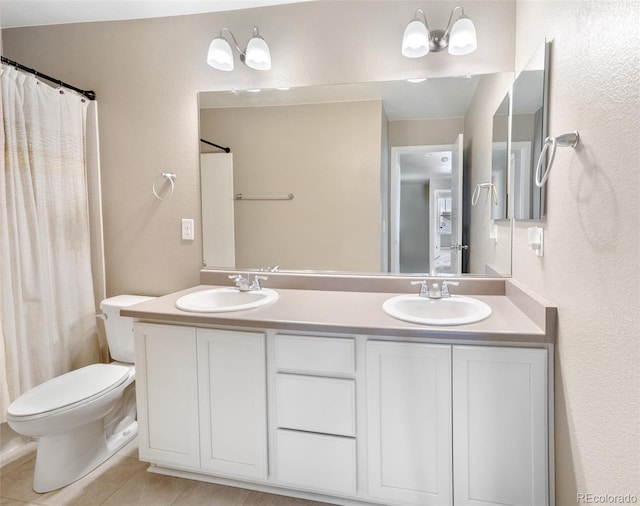 bathroom with tile patterned floors, double vanity, a sink, and toilet
