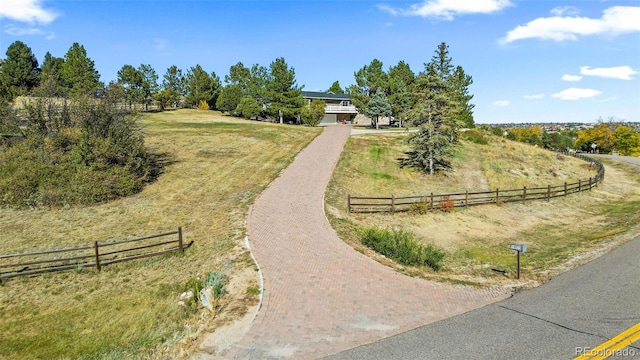 view of property's community featuring a lawn and a rural view