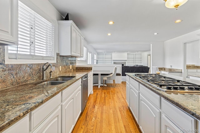 kitchen featuring dark stone counters, sink, white cabinetry, appliances with stainless steel finishes, and light hardwood / wood-style floors