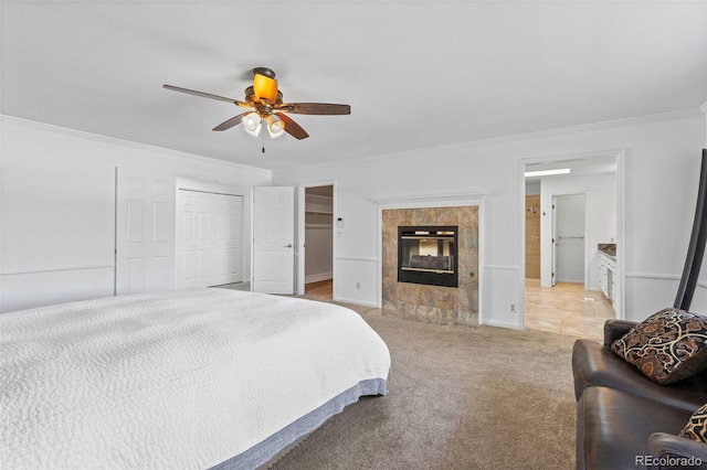 bedroom with a fireplace, a closet, ceiling fan, light carpet, and crown molding