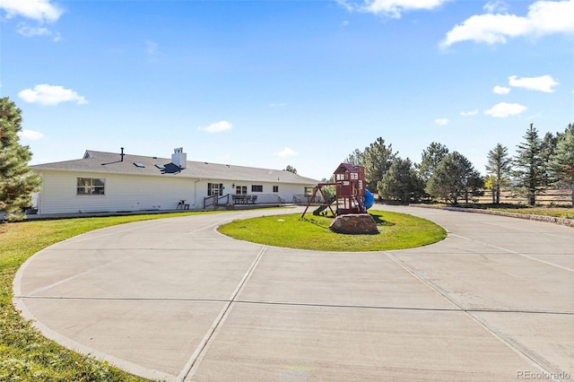 view of front of property featuring a front yard and a playground