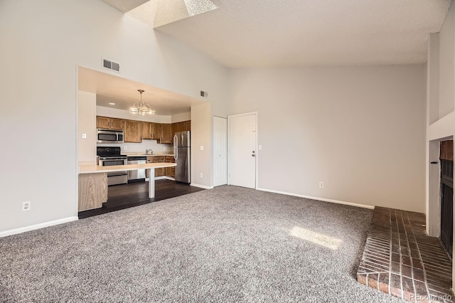 4899 S Dudley St Unit 20G, Littleton, CO 80123 - unfurnished living room featuring a chandelier, high vaulted ceiling, dark carpet, baseboards, and a textured ceiling