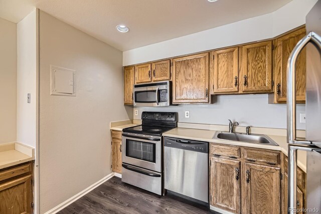 4899 S Dudley St Unit 20G, Littleton, CO 80123 - kitchen featuring appliances with stainless steel finishes, a sink, dark wood-type flooring, brown cabinets, and light countertops