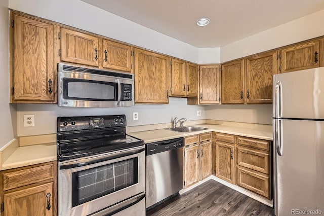 4899 S Dudley St Unit 20G, Littleton, CO 80123 - kitchen with appliances with stainless steel finishes, brown cabinets, light countertops, dark wood-type flooring, and recessed lighting