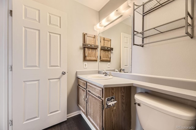 4899 S Dudley St Unit 20G, Littleton, CO 80123 - half bathroom featuring vanity, toilet, wood finished floors, and baseboards