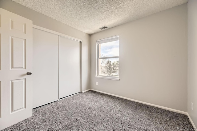 4899 S Dudley St Unit 20G, Littleton, CO 80123 - unfurnished bedroom featuring carpet flooring, a textured ceiling, a closet, and baseboards