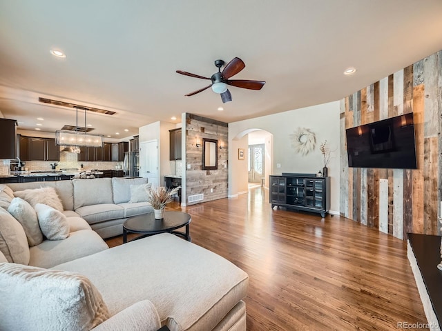 living room with arched walkways, recessed lighting, visible vents, ceiling fan, and wood finished floors