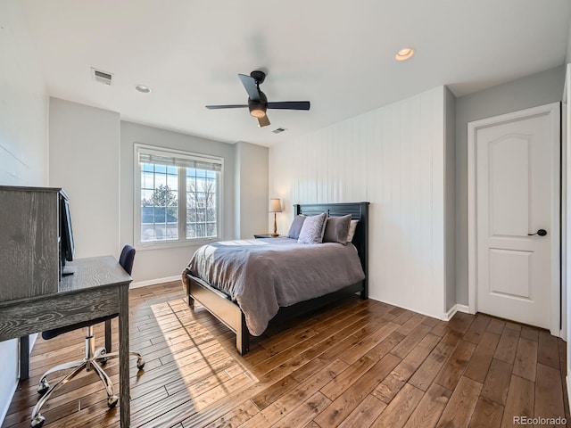 bedroom with visible vents, ceiling fan, baseboards, and wood finished floors