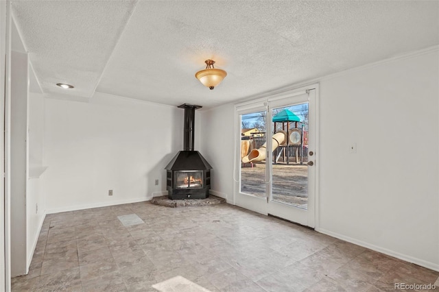 2613 Wren Dr, Colorado Springs, CO 80909 - unfurnished living room featuring a textured ceiling, a wood stove, and baseboards