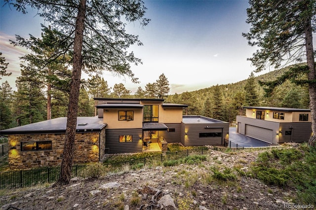 32651 Buffalo Creek Rd, Evergreen, CO 80439 - contemporary home with stone siding, a view of trees, and a detached garage