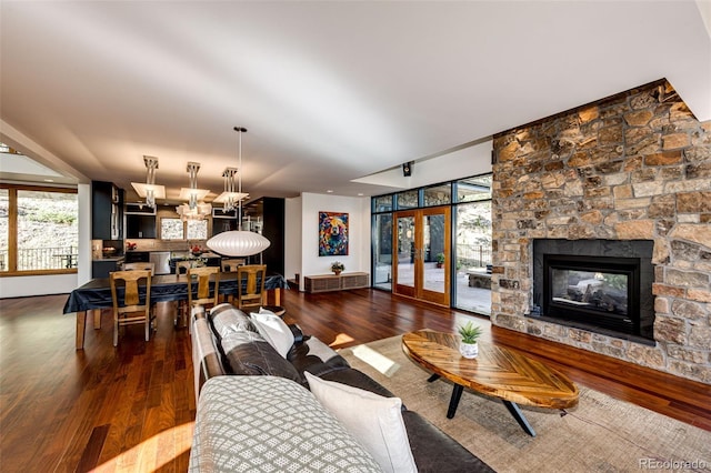 32651 Buffalo Creek Rd, Evergreen, CO 80439 - living room featuring wood finished floors, a fireplace, a chandelier, and french doors