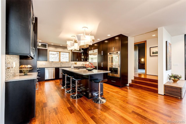 32651 Buffalo Creek Rd, Evergreen, CO 80439 - kitchen featuring appliances with stainless steel finishes, a kitchen bar, a sink, wood finished floors, and light countertops