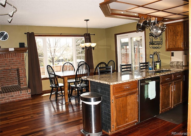 kitchen with dark hardwood / wood-style flooring, dishwasher, pendant lighting, and light stone counters