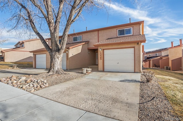 front of property featuring central AC and a garage