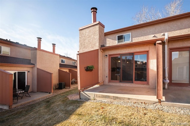 rear view of property with central air condition unit and a patio