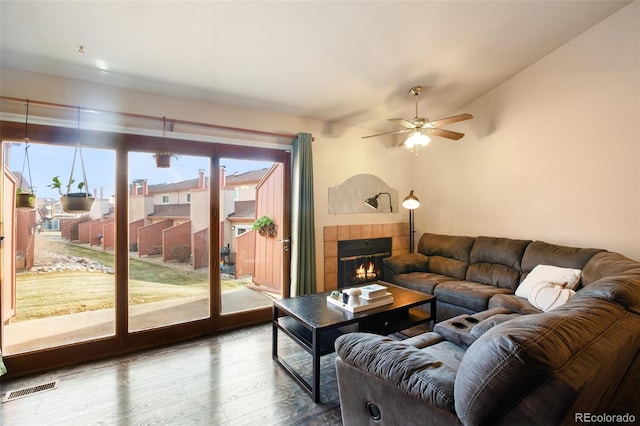 living room with a wealth of natural light, a fireplace, ceiling fan, and hardwood / wood-style flooring