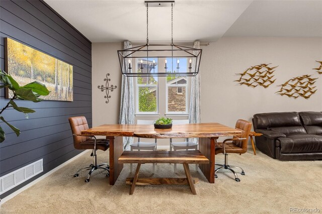 24702 E Ontario Dr, Aurora, CO 80016 - dining room featuring wooden walls, carpet floors, and a chandelier