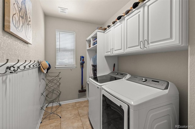 24702 E Ontario Dr, Aurora, CO 80016 - laundry area with washing machine and dryer, cabinet space, light tile patterned flooring, and baseboards